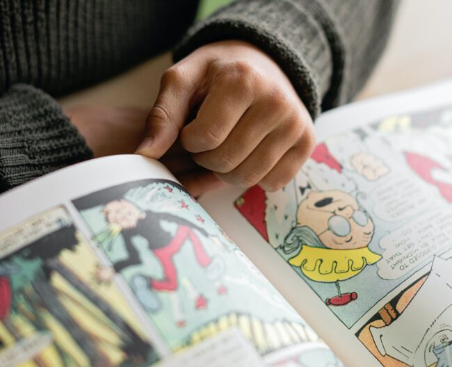 A cropped, zoomed-in picture of a person reading a comic book